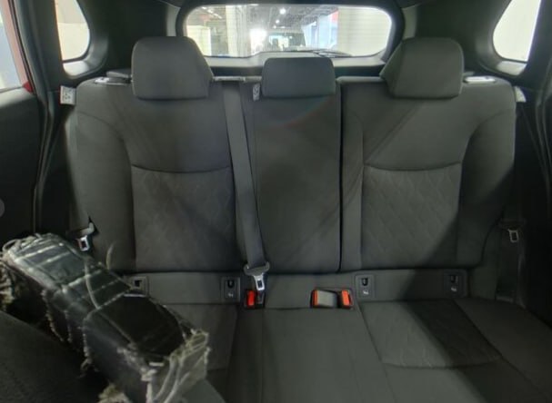 Салон Toyota Corolla Cross: задние сиденья в тканевой обивке, три подголовника и ремни безопасности, общий вид задней части салона.