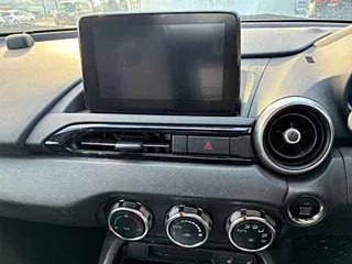 Мультимедийный экран и элементы климат-контроля Mazda Roadster, центральная панель с рабочим экраном и круглыми дефлекторами вентиляции.