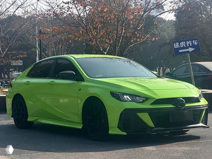 Зелёный GAC Leopard с другого бокового ракурса; виден низкий профиль, спортивные диски и подчёркнутые дизайнерские линии кузова на улице.