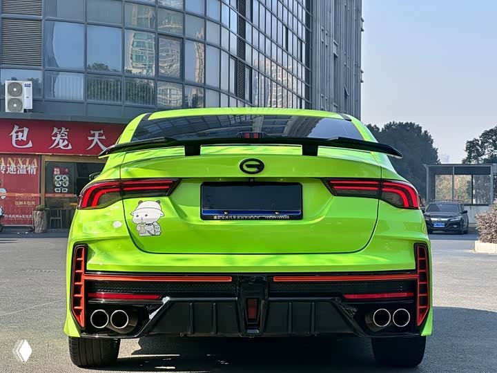 Крупный план задней части зелёного GAC Leopard: спойлер, стильный бампер с диффузором и четыре патрубка выхлопа; на багажнике заметна наклейка.