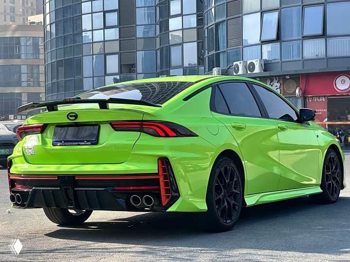 Три четверти сзади зелёного GAC Leopard: видно сочетание линий задней части, фонари и оформление бампера, автомобиль на городской стоянке.