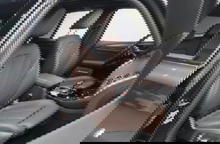 Передние сиденья BMW X3 M Sport в коричневой коже, вид через открытую дверь — интерьер и регулировки сидений видны хорошо.