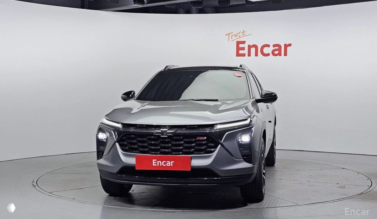 Ещё один фронтальный крупный план серебристого Chevrolet Trax RS в студийной обстановке Encar — акцент на решётке, эмблеме и фарах.