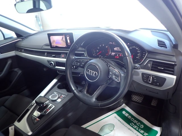 Салон Audi A4 2018: руль, приборная панель, мультимедиа‑экран и центральная консоль в аккуратном состоянии, фото изнутри.