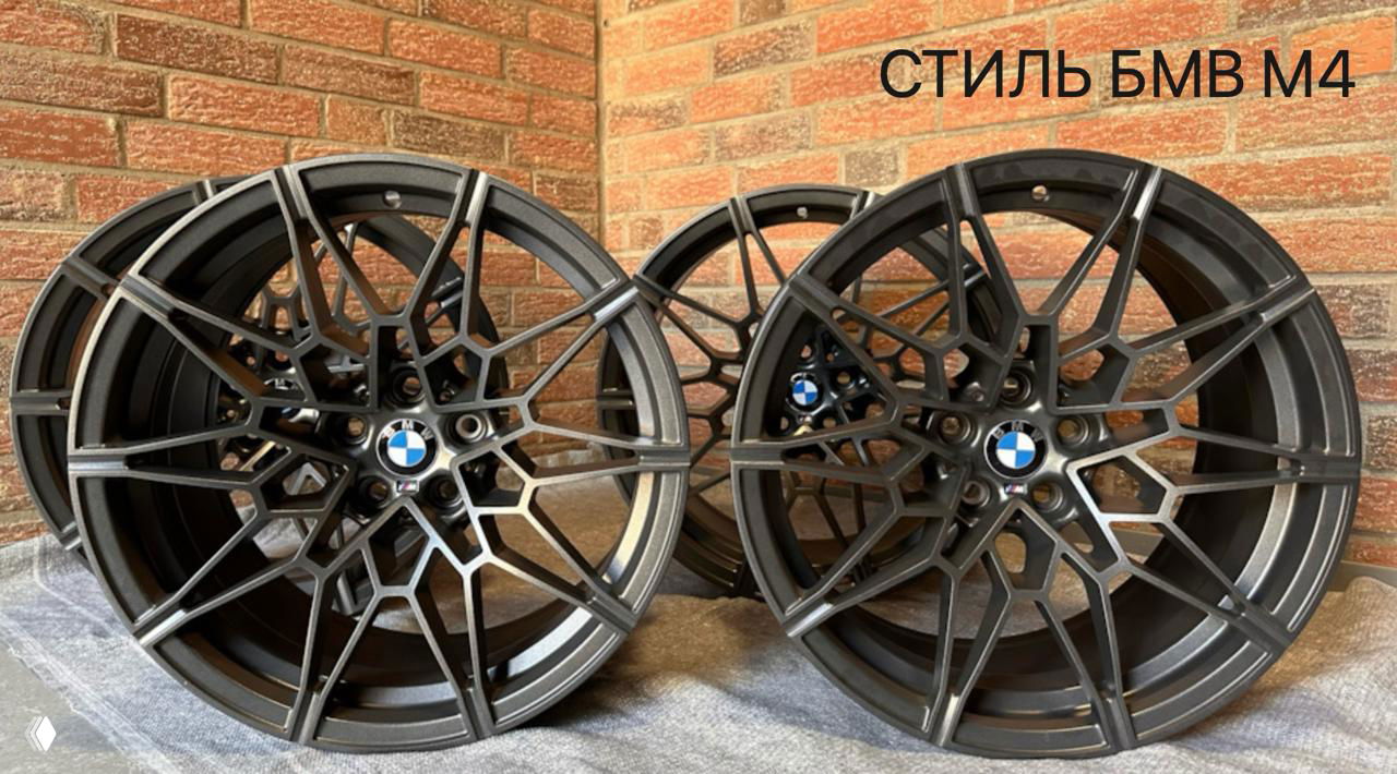 Тёмные многоспицевые диски в стиле BMW M4 на фоне кирпичной стены, подчёркивающие спортивный и агрессивный характер дизайна.