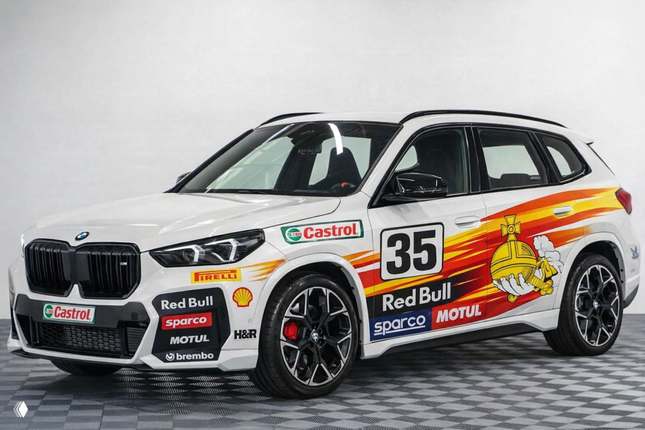 BMW X2 с яркими желто-красными полосами, логотипами Red Bull, Castrol и другими, вид спереди-сбоку в студийном освещении
