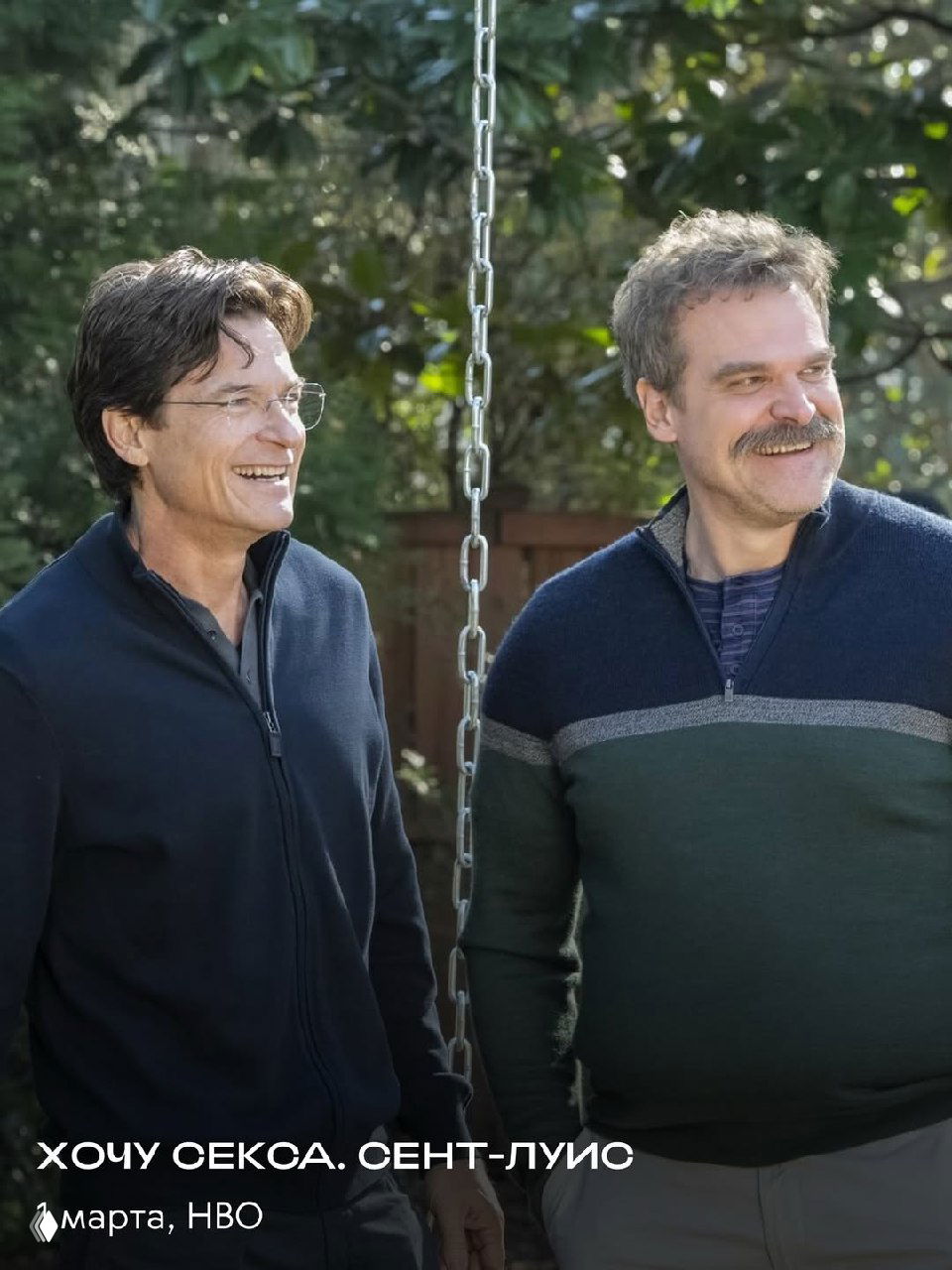 Уличный или загородный кадр с персонажами фильма «Молодой Шерлок»: мужчины и женщины на природе, видны деревья и световые искажения.