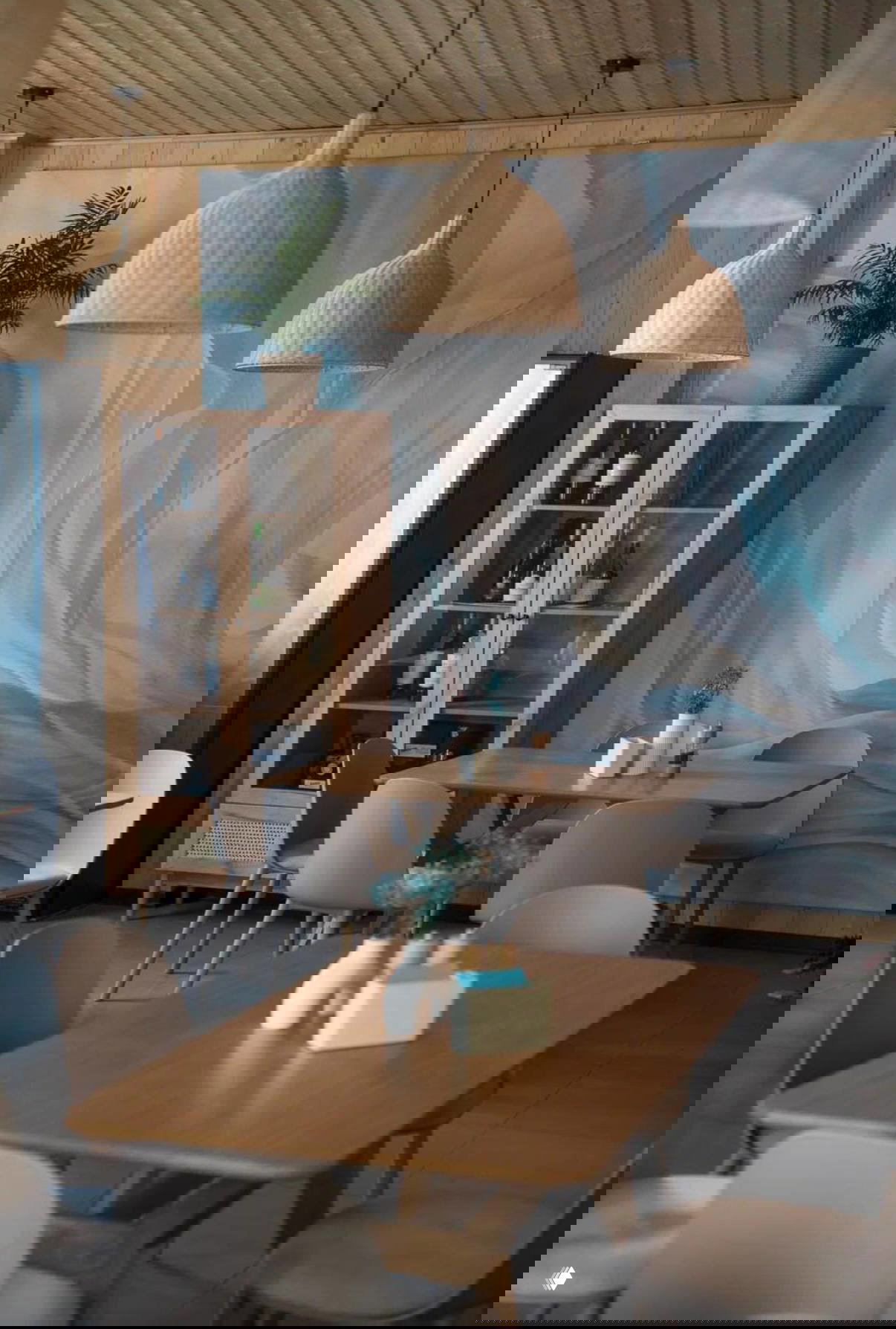 Обеденный зал с деревянными столами и плетёными подвесными светильниками, спокойная атмосфера и декоративные элементы на стене.